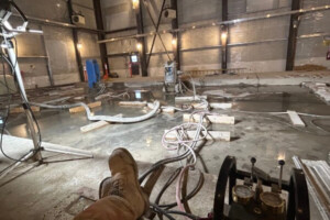 KJs cutting setting up equipment in large empty hangar
